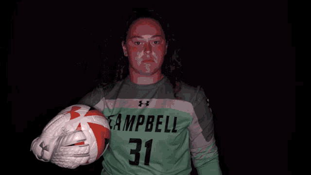 a girl holding a soccer ball wearing a campbell 31 jersey