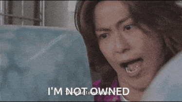 a woman sitting in front of a fan with the words " i 'm not owned " on the bottom right