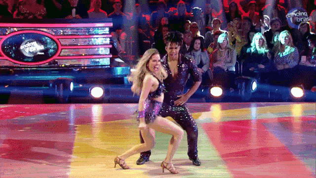 a man and a woman are dancing on dancing with the stars in front of a crowd