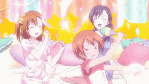 a group of anime girls are sitting on a bed with their arms outstretched .