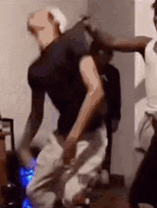 a man in a black shirt is dancing with another man in a white shirt in a room .
