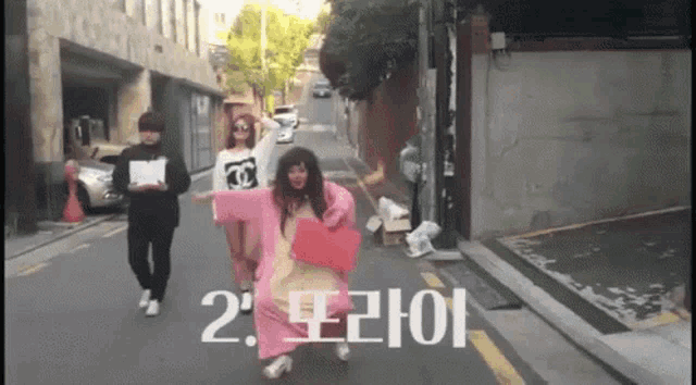 a group of people walking down a street with the number 2 in white