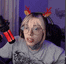 a woman wearing a reindeer headband and headphones is talking into a microphone .