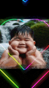 a little boy is smiling in front of a waterfall with a neon heart around him