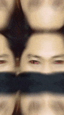 a blurry picture of a person 's face with a black band around their eyes