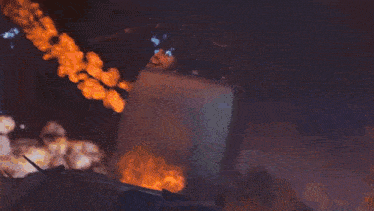 a person is standing in front of a huge fireball