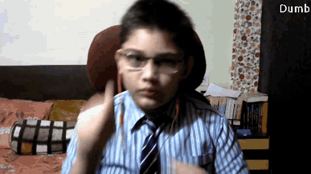 a young boy wearing glasses and a tie with the words dumb below him