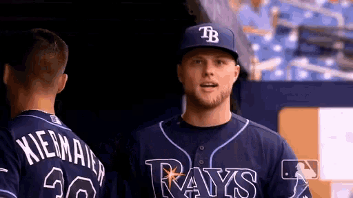 two baseball players wearing rays uniforms are talking to each other