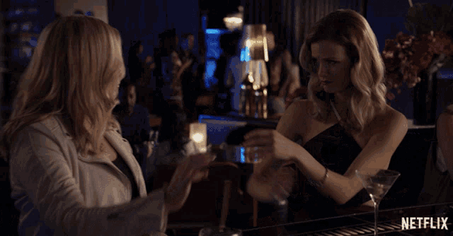 two women sitting at a bar with netflix written on the bottom
