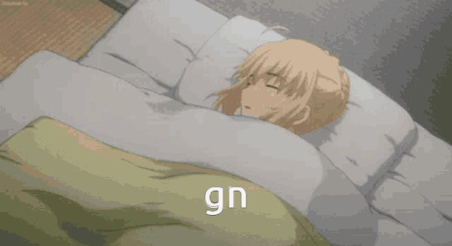 a girl is sleeping in a bed with the word gn written on the blanket