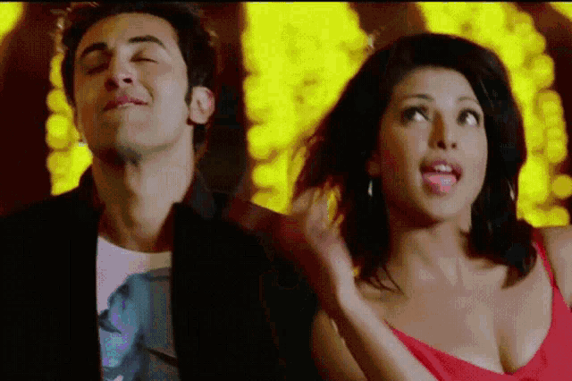 a man and a woman are standing next to each other with the woman sticking her tongue out