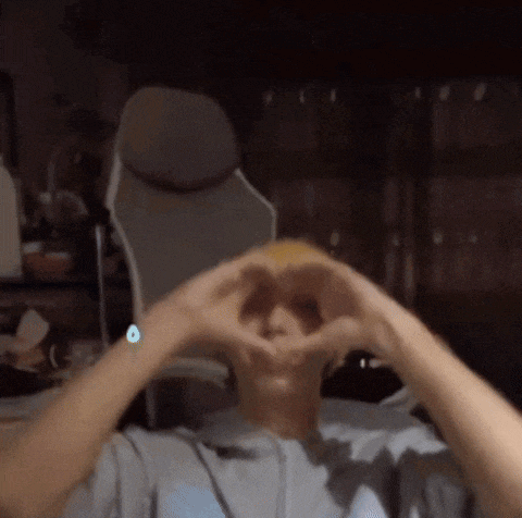 a man is making a heart shape with his hands