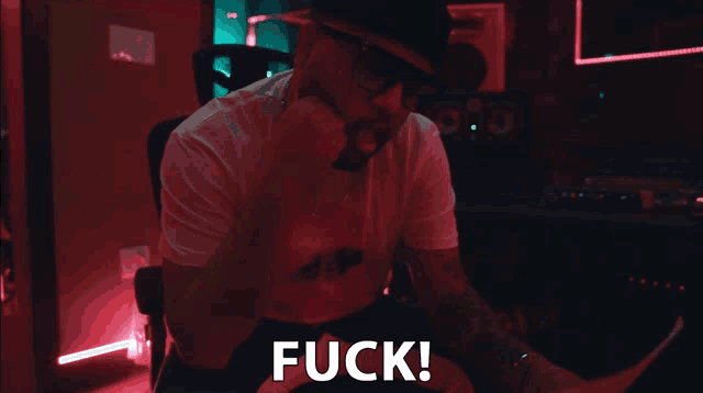 a man in a hat and sunglasses says fuck in a dark room
