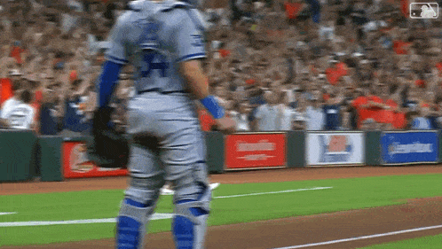 a baseball player in a blue uniform with the number 24 on the back is standing on the field .