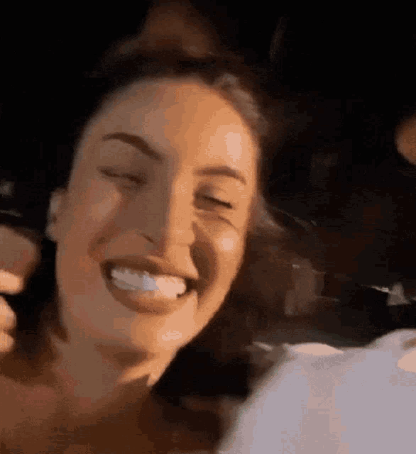a woman is smiling with her eyes closed while a man holds her hair