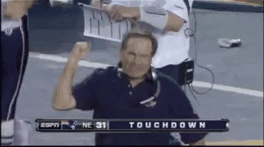 a man stands in front of a scoreboard that reads touchdown