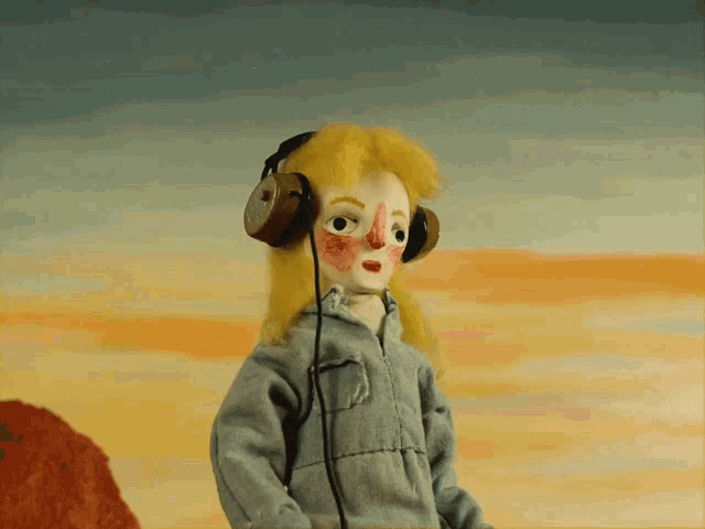 a puppet wearing headphones is standing in front of an orange sky