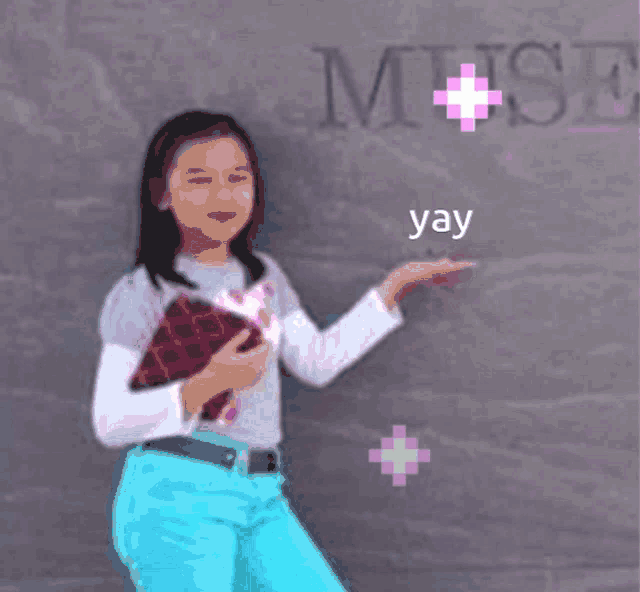 a girl standing in front of a wall with the word muse written on it