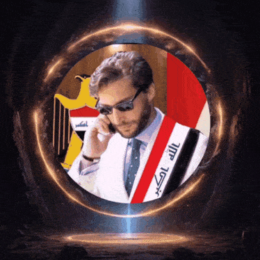 a man wearing sunglasses talks on a cell phone in front of a flag with arabic writing
