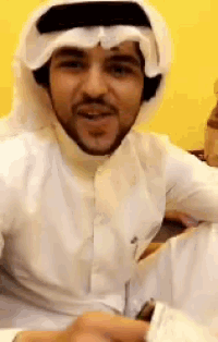 a man with a beard wearing a white shirt and a head scarf