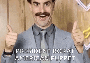 a man in a suit and tie is giving a thumbs up sign .