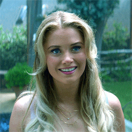 a woman with long blonde hair and blue eyes is smiling