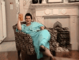 a woman in a blue dress is sitting in a leopard print chair