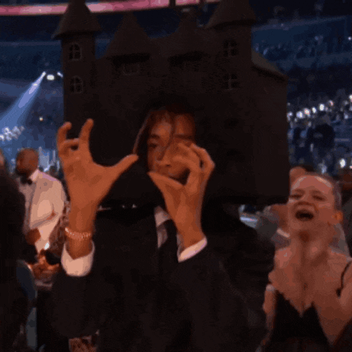 a man in a suit and tie is wearing a castle hat on his head