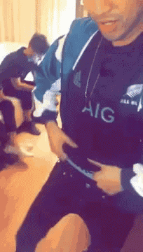 a man wearing a black aig shirt is holding his waist