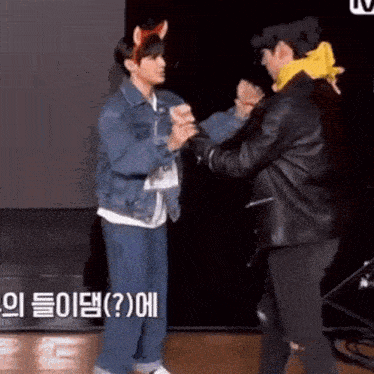 two men are standing next to each other and shaking hands .