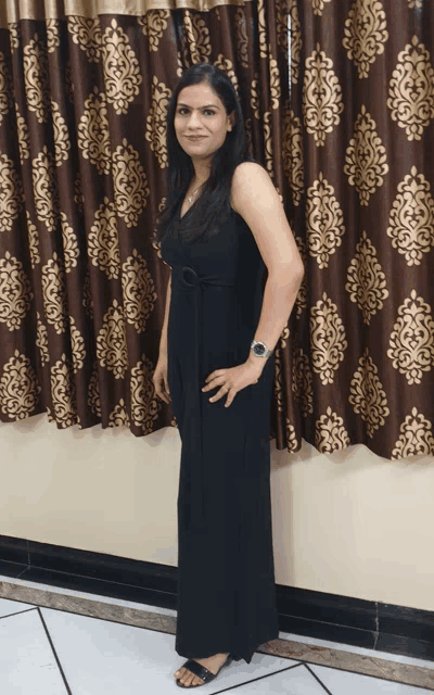 a woman in a black dress is standing in front of a window