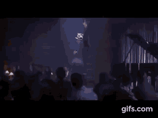 a man in a suit and tie is laughing with a woman in a crowd .