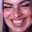 a close up of a woman 's face with her eyes closed smiling .