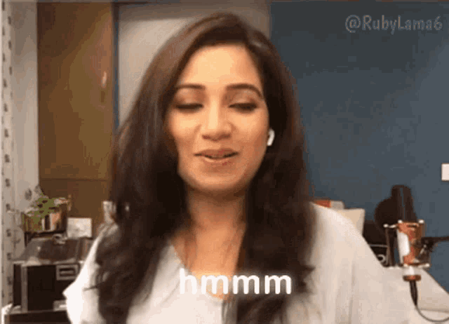 a woman is wearing headphones and says hmmm