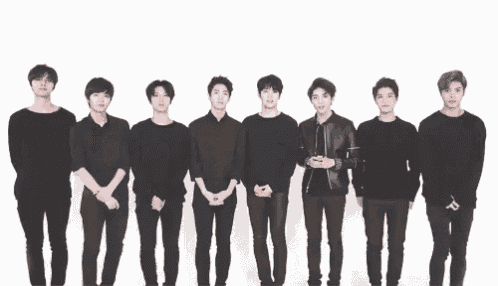 a group of young men are standing in a line wearing black