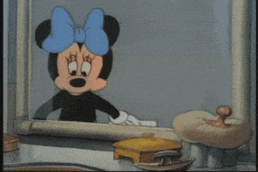 minnie mouse is brushing her teeth in front of a bathroom mirror