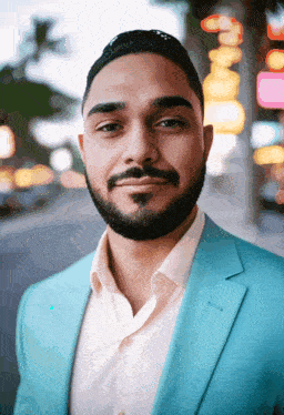 a man with a beard wearing a blue jacket and a white shirt