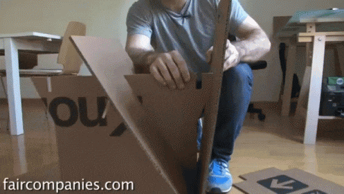 a man is working on a cardboard box that says you