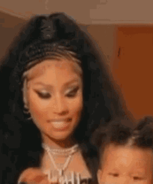 a woman is making a surprised face while holding a baby .