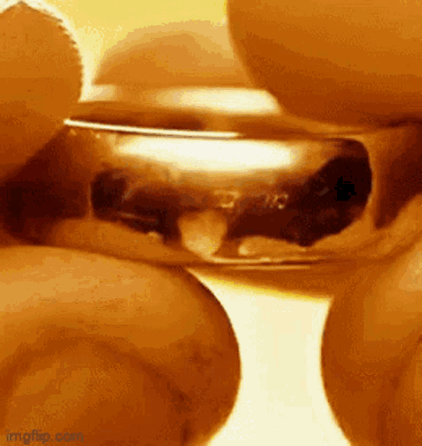 a close up of a person holding a gold ring in their hands