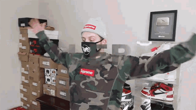 a man wearing a supreme sweatshirt and a mask