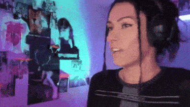 a woman wearing headphones is standing in front of a wall with pictures on it .