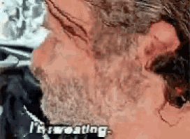a close up of a man 's face with the words i 'm sweating written on it