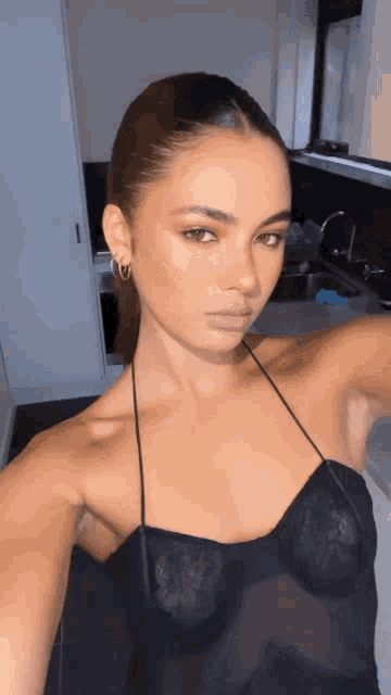 a woman is taking a selfie in a kitchen