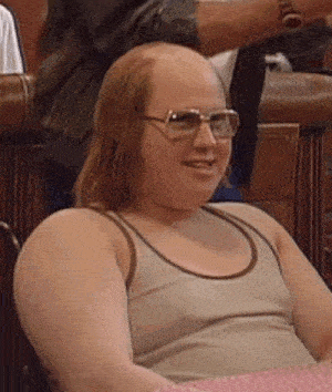 a bald man wearing sunglasses and a tank top is smiling .
