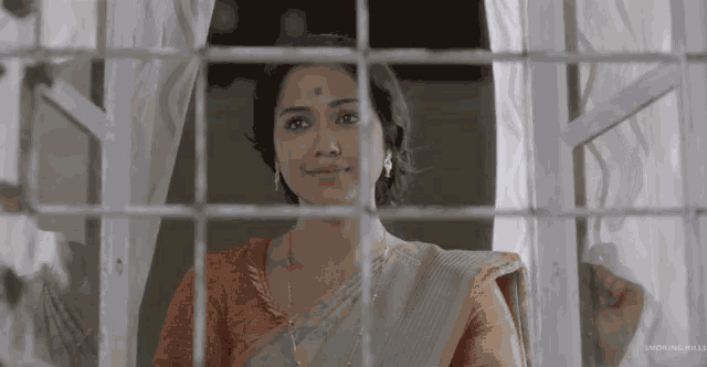 a woman looking out of a window with the words smoking kills written below her