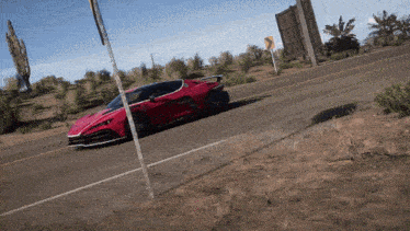 a red sports car is driving down a dirt road