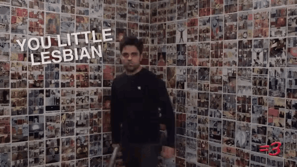 a man stands in front of a wall of pictures with the words you little lesbian written on it