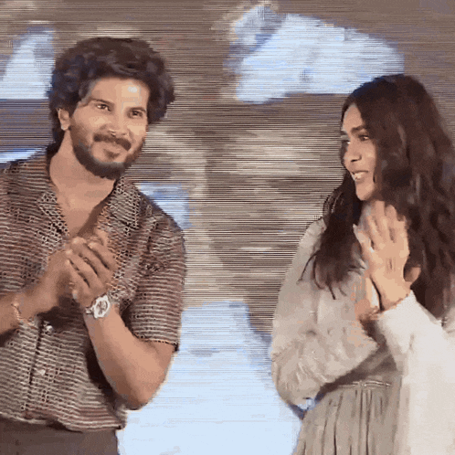 a man and a woman are standing next to each other and smiling