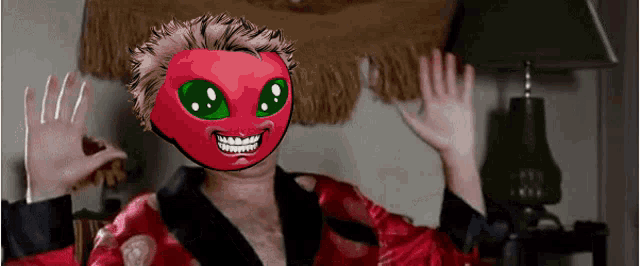 a man wearing a red mask with green eyes is waving